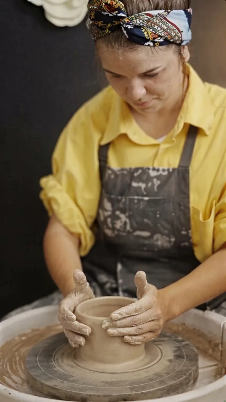 Potter shaping clay on a wheel, after