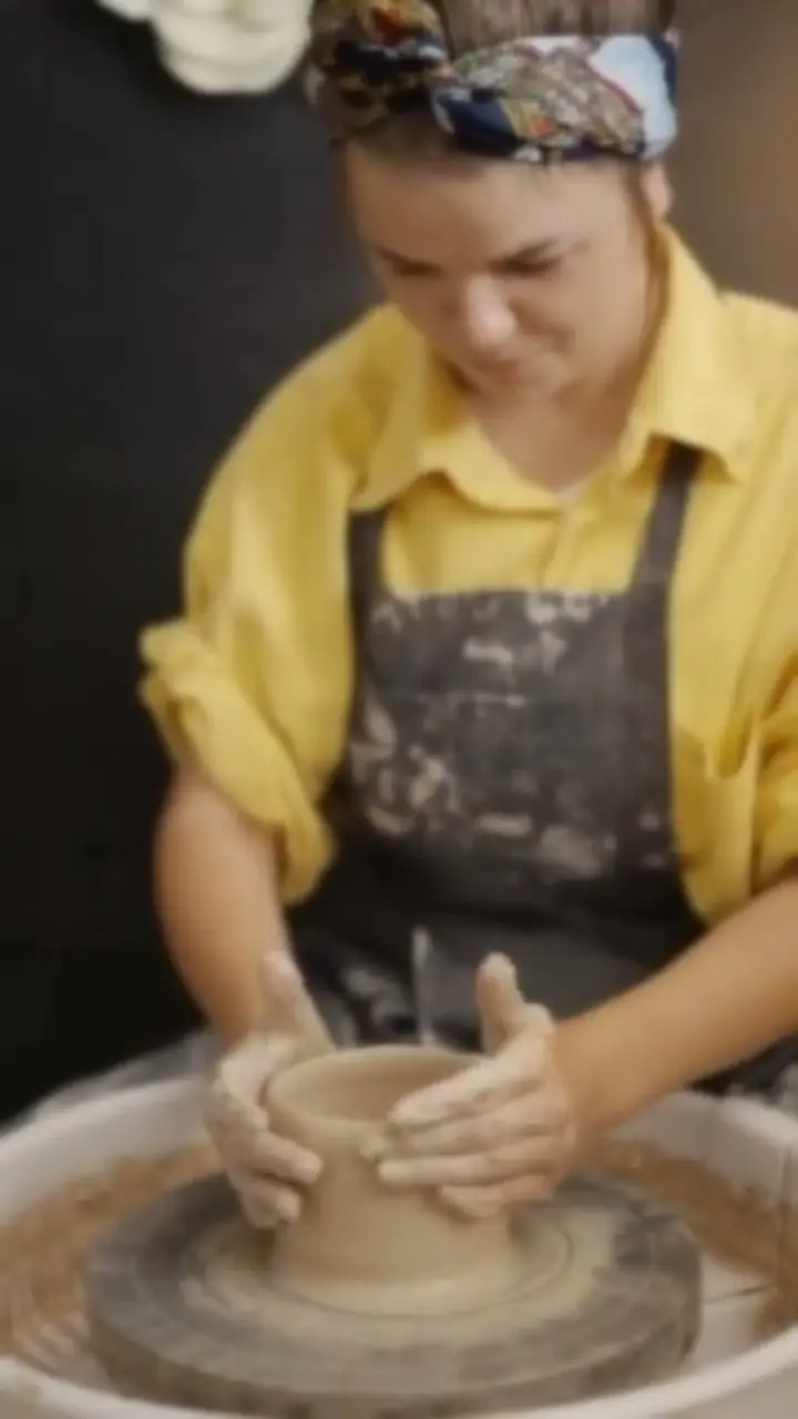 Potter shaping clay on a wheel, before